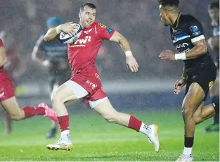  ??  ?? He’s away: Gareth Davies breaks past Anthony Watson to set up Scarlets’ try