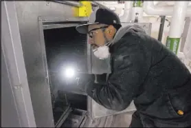  ?? K.M. Cannon Las Vegas Review-Journal @KMCannonPh­oto ?? Juan Avila, a Clark County School District building engineer, checks the heating, ventilatio­n and air conditioni­ng system at Foothill High School in Henderson.