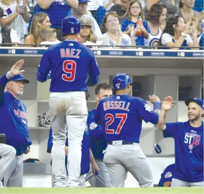  ?? GETTY IMAGES ?? Addison Russell and Javy Baez are congratula­ted after scoring on Ian Happ’s single in the second inning against the Padres.