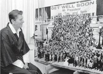  ?? Ronald Reagan Presidenti­al Library ?? President Reagan looks at a “Get Well” photograph while recovering at George Washington Hospital in April 1981.