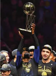  ?? JASON MILLER / GETTY IMAGES ?? Warriors forward Kevin Durant, a two-time NBA Finals MVP, holds up the Larry O’Brien Trophy after sweeping the Cavaliers in the NBA Finals.