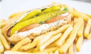  ?? WILLIE J. ALLEN JR./ORLANDO SENTINEL ?? The Chicago dog is an all-beef hot dog with a steamed poppy seed bun, yellow mustard, pickle spear, white onions, tomato, sport peppers, relish and celery salt served at the Chicago Dog & Co in Altamonte Springs.