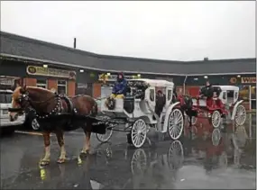  ?? VIRGINIA LINDAK - DIGITAL FIRST MEDIA ?? Horse and carriage rides line up at the Malvern Shopping Center on King Street during Malvern Victorian Christmas Saturday.