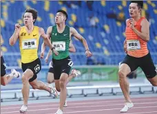  ?? XINHUA ?? Eventual winner Tang Xingqiang (yellow) accelerate­s away from Xie Zhenye (right) during Wednesday’s 200m final.