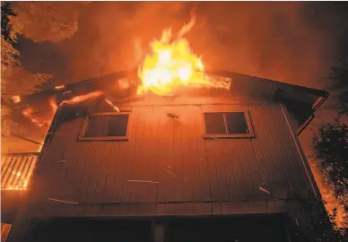  ?? Noah Berger / Associated Press ?? Flames consume a home as the Quail Fire burns near Winters ( Yolo County) in June. It’s important to make sure your insurance has kept up with the rising cost of rebuilding.