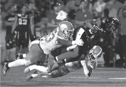  ?? CP PHOTO ?? Ottawa Redblacks player R.J. Harris tries to leap past the tackle of B.C. Lions player Jordan Herdman and Winston Rose of during a game in Ottawa on Friday.