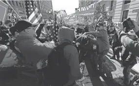  ?? JULIO CORTEZ/AP ?? A fight breaks out between supporters of President Donald Trump and counterpro­testers on Saturday in Washington.