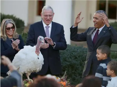  ?? AP ?? President Barack Obama, with his nephews Aaron Robinson and Austin Robinson, and National Turkey Federation Chairman John Reicks, pardons the National Thanksgivi­ng Turkey, Tot, during a ceremony in the Rose Garden of the White House in Washington. —