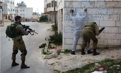  ??  ?? A Palestinia­n is checked by Israeli soldiers patrolling the streets of the West Bank city of Hebron in 2015. Photograph: Menahem Kahana/ AFP/Getty Images