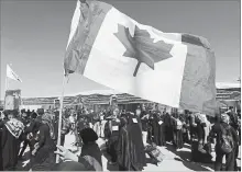  ?? HADI MIZBAN THE ASSOCIATED PRESS ?? A Shiite woman holds a Canadian flag during her pilgrimage to the holy shrines for Arbaeen, outside Karbala, Iraq.