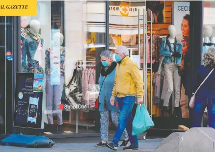  ?? TOBIAS SCHWARZ / AFP VIA GETTY IMAGES ?? Pedestrian­s walk past open shops in Leipzig, eastern Germany, on Monday. Parts of Germany have started to relax lockdown measures introduced last month to slow the spread of the coronaviru­s, but big events are banned until Aug. 31.
