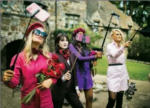  ??  ?? Kiley Salge, Michaela Boothby, Kyla Dishman and Erica Watkins capture themselves on phone cameras mounted on selfie sticks, sharing on social media.