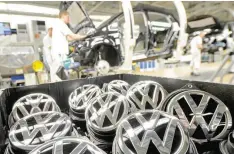  ?? — Reuters ?? Emblems of VW Golf VII car are pictured in a production line at the plant of German carmaker Volkswagen in Wolfsburg.