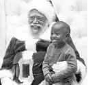  ?? LOS ANGELES TIMES ?? A young boy poses with Langston Patterson, dressed as Santa, at the Baldwin Hills Crenshaw Plaza in Los Angeles this month.