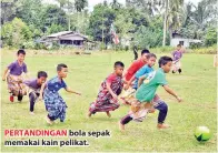  ??  ?? PERTANDING­AN bola sepak memakai kain pelikat.