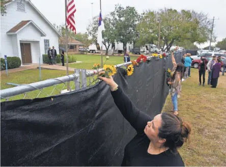  ??  ?? Rachel Vasquez places flowers outside First Baptist Church in Sutherland Springs as worshipers gathered in a large tent in an athletic field Sunday for the church’s first service since last week’s deadly shooting. COURTNEY SACCO/CALLER-TIMES