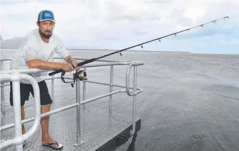  ?? Picture: JUSTIN BRIERTY ?? REEL APPEAL: Reg Allan tries his luck at Cairns Marina. This weekend is expected to be a bonanza for fishing.