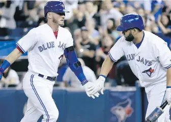  ??  ?? Toronto Blue Jays third baseman Josh Donaldson, left, celebrates a home run with teammate Kendrys Morales at the Rogers Centre in August.