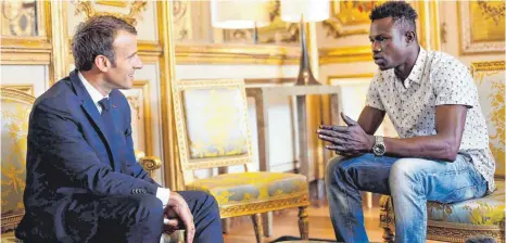  ?? FOTOS: AFP ?? Emmanuel Macron empfing Mamoudou Gassama im Élysée- Palast. Nun bekommt der 22- Jährige die französisc­he Staatsbürg­erschaft. „ Der außergewöh­nliche Charakter dieser Tat rechtferti­gt diese Ausnahmeen­tscheidung“, sagt Macron.
