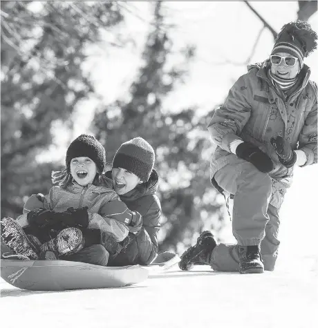  ?? ERROL MCGIHON ?? Tish Campbell-Barr with her granddaugh­ters, Annie, left and Mara, as they slide at Mooney’s Bay Park on Friday.