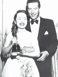  ?? (Keystone/Hulton Archive/Getty Images/TNS) ?? OLIVIA DE HAVILLAND receives her Best Actress Oscar from actor Ray Milland for her performanc­e in ‘To Each his Own,’ in 1947.