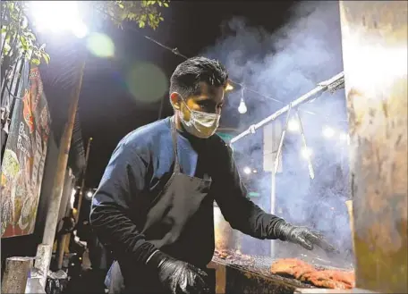  ?? Gary Coronado Los Angeles Times ?? DANIEL GOMEZ cooks at Tacos a Cabron in East L.A. Haters should leave street food vendors alone, Gustavo Arellano writes.