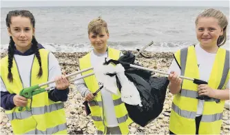  ??  ?? Elly Loftus, Andrew Readymarch­er and Hannah Dickinso with some of the rubbish.