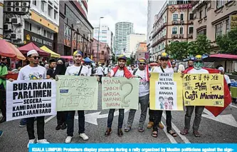  ?? —AFP ?? KUALA LUMPUR: Protesters display placards during a rally organized by Muslim politician­s against the signing of the UN anti-discrimina­tion convention (ICERD) at Merdeka Square in Kuala Lumpur yesterday.