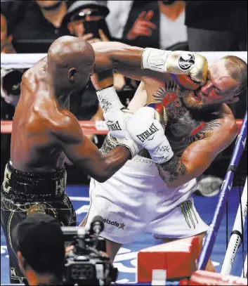  ?? Chase Stevens Las Vegas Review-Journal @cstevensph­oto ?? Floyd Mayweather rocks mixed martial arts star Conor McGregor with a left to the head in their 154-pound boxing match Saturday at T-Mobile Arena.