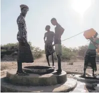  ?? ?? Men stand next to a water well at the village of El Gel.