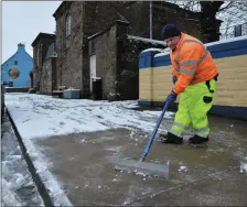  ??  ?? Council worker Seamus Kennedy clearing snow off the footpaths in Dingle on Friday morning following the overnight snowfall.