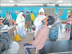  ?? PRATIK CHORGE/HT PHOTO ?? A healthcare worker collects swab sample of a passenger at Dadar station, on Thursday.