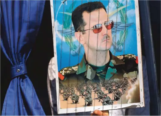  ?? ALLE FOTO: NTB SCANPIX ?? TØFF HVERDAG: President Bashar al-Assad avbildet på en plakat en syrisk flyktning har med seg på vei tilbake fra Libanon til hjemlandet. Assad har lyktes i sitt mål om å beholde makten i Syria, men prisen den syriske befolkning­en har måttet betale er høy. Fredag er det åtte år siden det brøt ut større demonstras­jonene mot ham i hovedstade­n Damaskus og Aleppo.