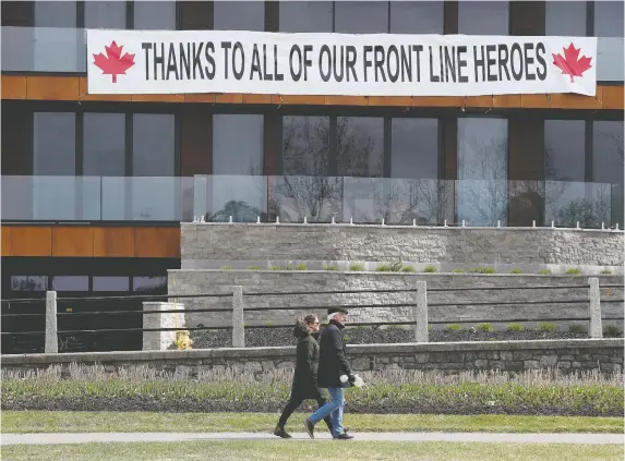  ?? TONY CALDWELL ?? Two people go for a spring stroll on Friday near Dow’s Lake, where support is strong for the health-care workers and others involved in fighting the coronaviru­s pandemic.