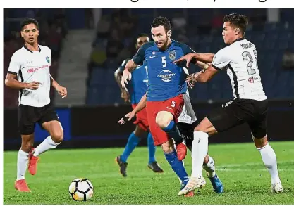  ??  ?? Out of my way: JDT’s Fernando Elizari (centre) trying to get past Pahang defender Mohamad Muslim Ahmad during the Super League match at the Larkin Stadium on Friday. — Bernama