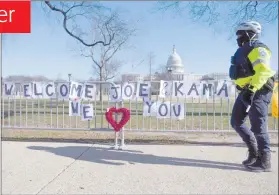  ?? Photo: Nampa/AFP ?? Big moment awaits… A police officer passes signs of support for President-elect Joe Biden and Vice President-elect Kamala Harris near the US Capital in Washington, DC.