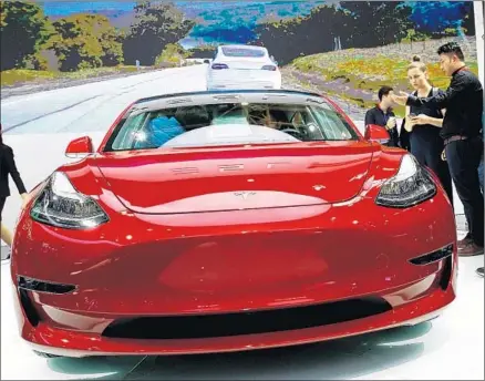  ?? Roman Pilipey EPA/Shuttersto­ck ?? DIRECTING a tweet at short sellers, Tesla chief Elon Musk said Friday that “Flamethrow­ers should arrive just in time.” That may be a reference to Tesla’s plans to announce a “gigafactor­y” in China soon. Above, a Model 3 is on display at a car show in...