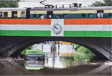  ??  ?? A DTC bus almost submerged at waterlogge­d Minto Bridge underpass after a heavy downpour in Delhi on Sunday