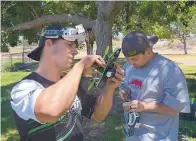  ??  ?? Shaun Taylor, left, and James Perez check the radio signal connection between a quadcopter and the first person view goggles. They are members of Team Multistar, a racing team that is sponsored by online hobby store HobbyKing.