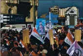  ?? KHALID MOHA — THE ASSOCIATED PRESS ?? Supporters of the Popular Mobilizati­on Forces hold a poster during a protest in Tahrir Square, Iraq, on Sunday.