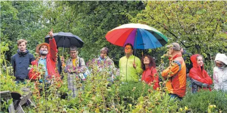  ?? FOTO: MILENA HÄNISCH ?? Trotz Nieselwett­er: Die Rundgänge durch den Garten waren begehrt. Michael Schick (2.v.l.) erklärt geduldig.