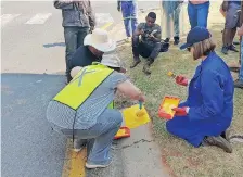  ??  ?? RESIDENTS repainting street names after the city failed to respond to calls.