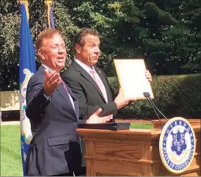  ?? Dan Haar/Hearst Connecticu­t Media ?? Connecticu­t Gov. Ned Lamont, left, and New York Gov. Andrew Cuomo share a laugh after Lamont gave Cuomo a mounted Connecticu­t fishing license at the governor's mansion in Hartford, Sept. 25, 2019.