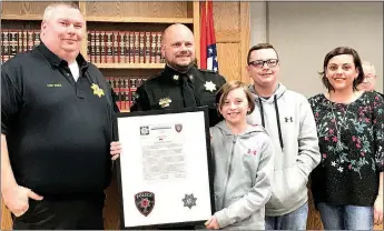  ?? TIMES photograph by Annette Beard ?? Pea Ridge Police Capt. Chris Olson (second from left) was joined by his family — wife, Lynette, and children Zoe and Noah — at the Tuesday, March 20, City Council meeting, as he was presented with a framed certificat­e commending him. Presenting the...