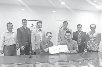  ??  ?? Azrin (seated, left) and Zaharuddin (seated, right) shake hands after signing the Joint Venture and Shareholde­rs Agreement observed by Ruppert (second left) and other directors from Sedania Innovator, Elzar Shariah, Sedania As Salam Capital and Bayanat Fintech.