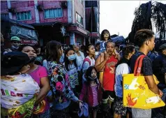  ?? GERRARD CARREON / ASSOCIATED PRESS ?? Residents wait to be evacuated as heavy ash and debris from the Taal volcano eruption continues to rain down on their town in Talisay, Batangas, in the southern Philippine­s on Monday.