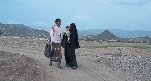  ?? TYLER HICKS PHOTOS THE NEW YORK TIMES ?? Khalil Hadi and Itanna Hassan Massani carry their son, Wejdan, from a clinic in Aslam. In Yemen, small but vital things, like a cab fare, become unattainab­le.