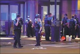  ?? Jose M. Osorio Chicago Tribune ?? POLICE gather in downtown Chicago. The city saw businesses damaged and ransacked in what the mayor called “straight-up felony criminal conduct.”