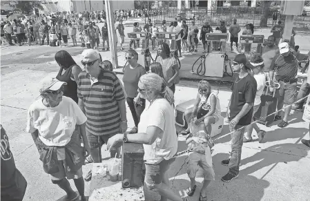  ?? JACK GRUBER/USA TODAY ?? People wait to buy ice from the Rose Ice and Coal Co. in Wilmington, N.C., on Monday.