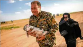  ?? —AFP ?? ESCAPING THE CALIPHATE Awoman weeps as a fighter of the Kurdish-led Syrian Democratic Forces helps her flee Baghouz in northern Syria.